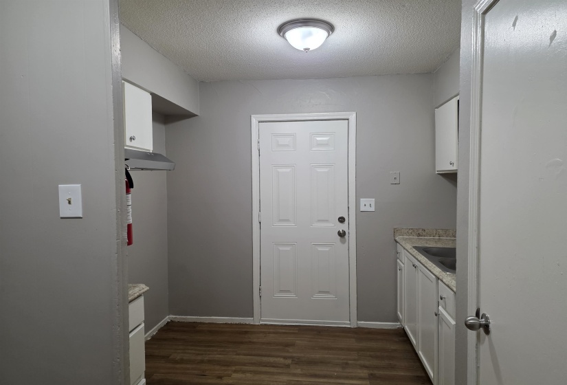 Washroom with a textured ceiling and dark wood finished floors