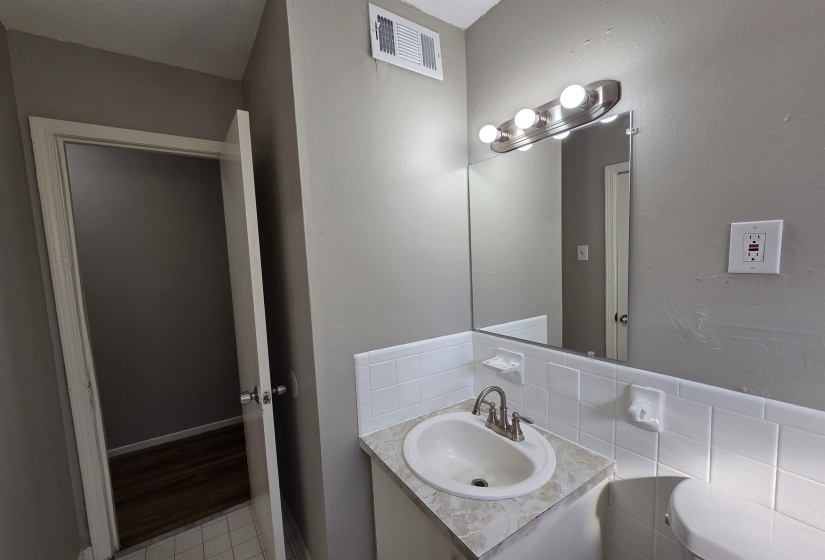 Bathroom featuring vanity, light tile patterned flooring, and tasteful backsplash