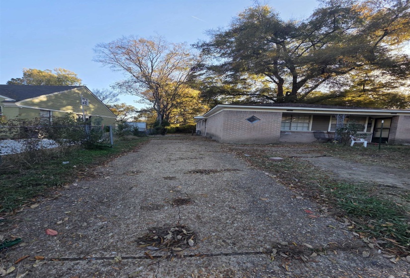 View of property exterior featuring driveway and brick siding