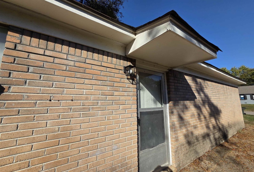 Property entrance featuring brick siding