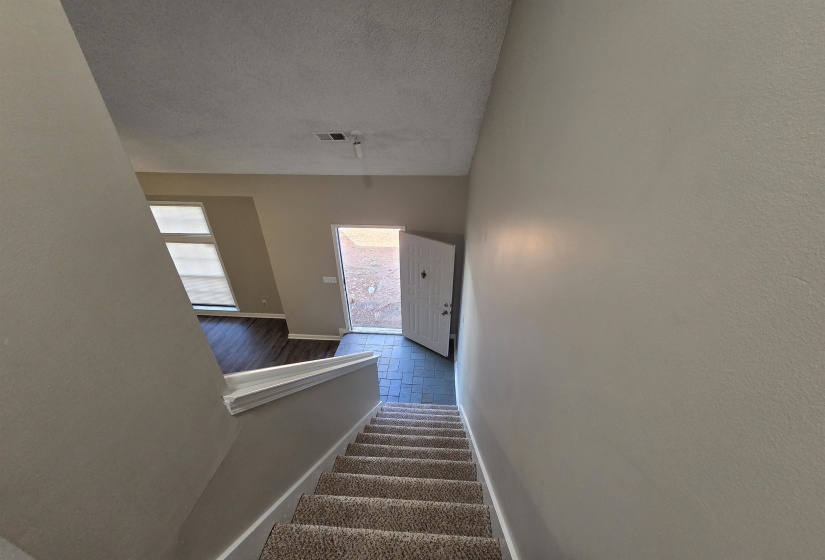 Stairway featuring baseboards and a textured ceiling