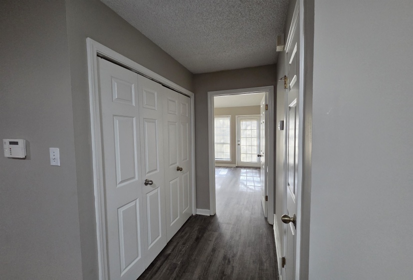 Corridor with dark wood finished floors and a textured ceiling