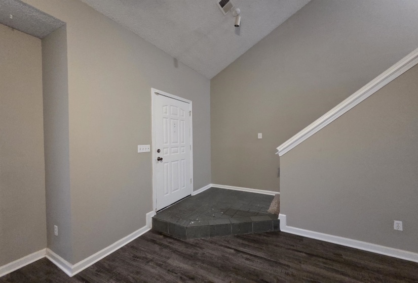 Entrance foyer featuring vaulted ceiling and dark wood finished floors