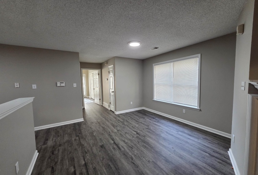 Spare room featuring dark wood-type flooring and a textured ceiling
