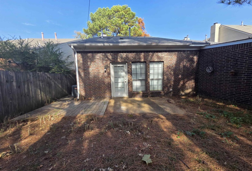 Back of property with brick siding and a wooden deck