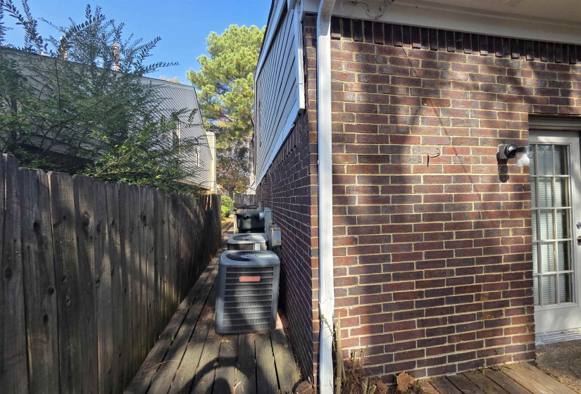 View of property exterior with brick siding and a wooden deck