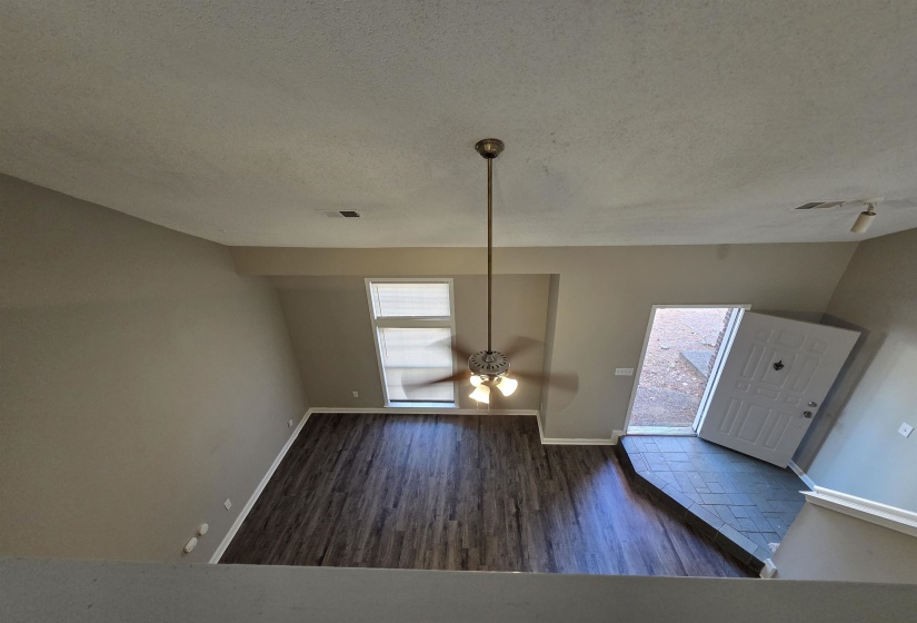 Entrance foyer with dark wood-style flooring, a textured ceiling, and a ceiling fan