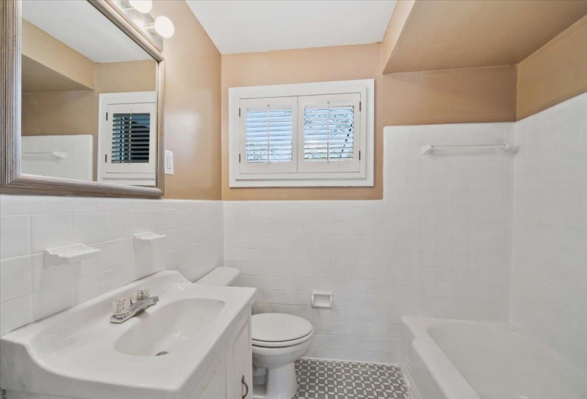 Bathroom with vanity, tile walls, and wainscoting