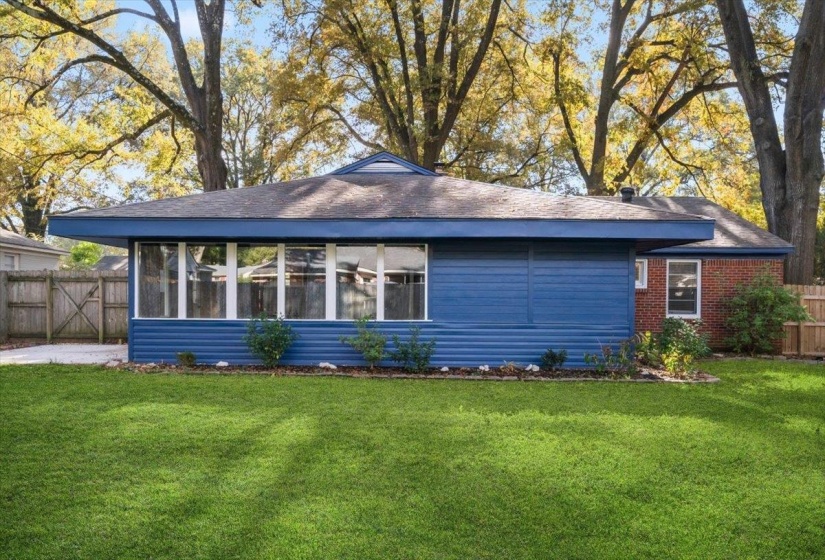 Back of house with a sunroom, brick siding, and a shingled roof