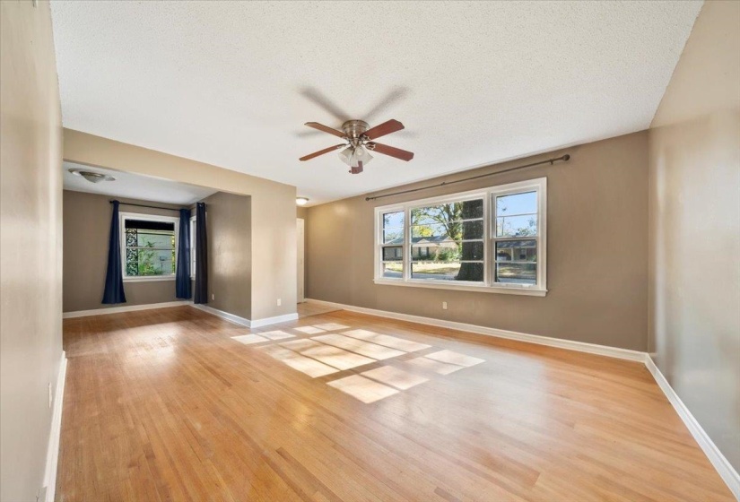 Empty room featuring light wood finished floors, a ceiling fan, and a textured ceiling
