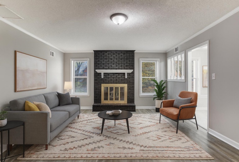 Living area with crown molding, a textured ceiling, wood finished floors, and a fireplace