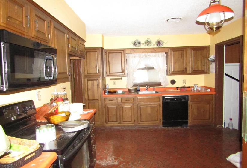 Kitchen featuring black appliances, brown cabinets, and light countertops
