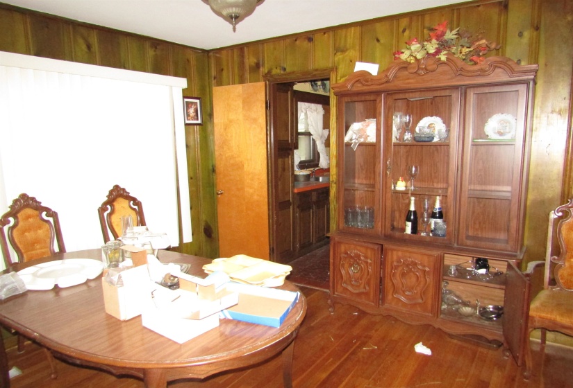 Dining room with wooden walls and dark wood finished floors