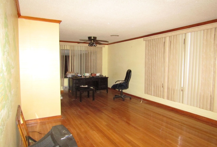 Office space featuring wood finished floors, crown molding, and ceiling fan