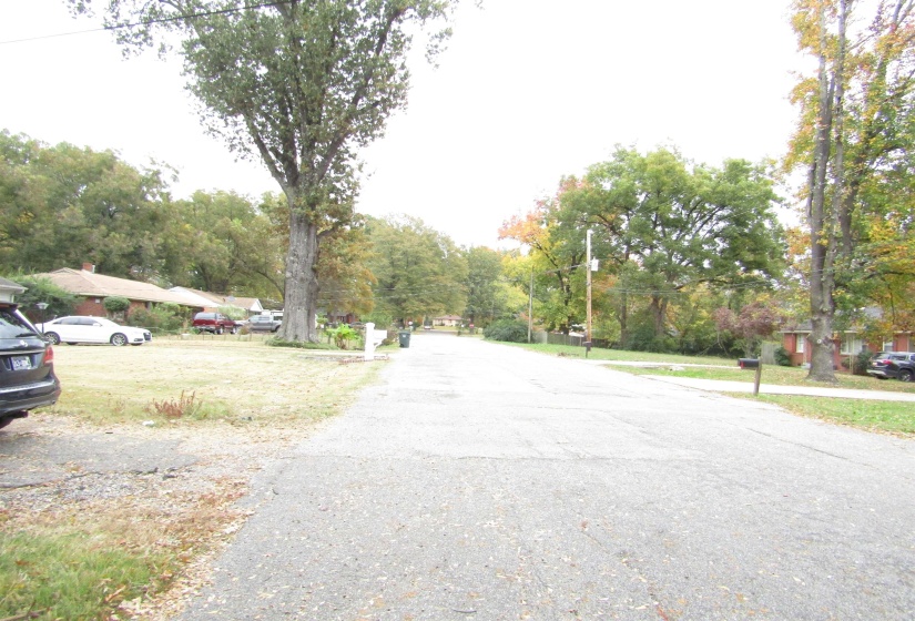 View of asphalt street with view of wooded area