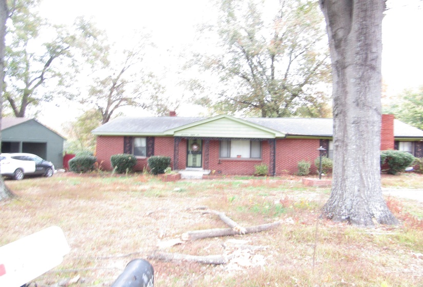 Ranch-style home featuring brick siding and an outdoor structure