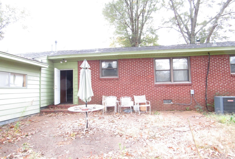 Rear view of property with brick siding and crawl space