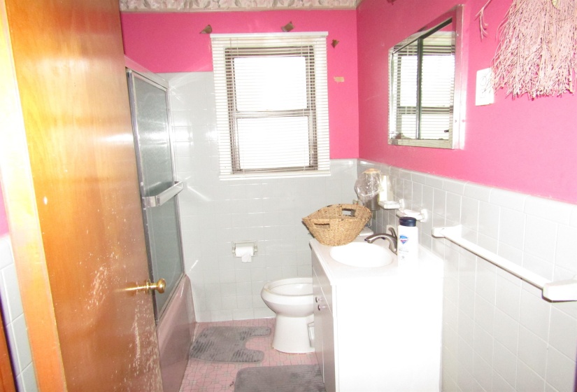 Bathroom with vanity, shower / bath combination with glass door, light tile patterned floors, and tile walls