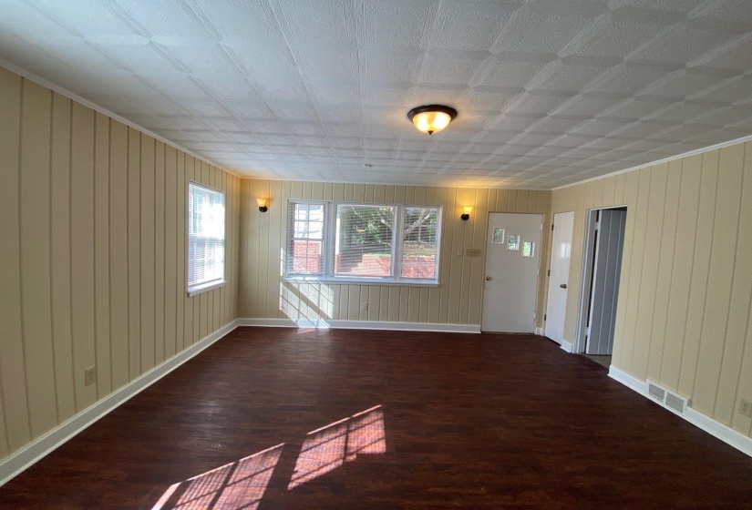 Unfurnished living room with dark wood-style floors and wooden walls