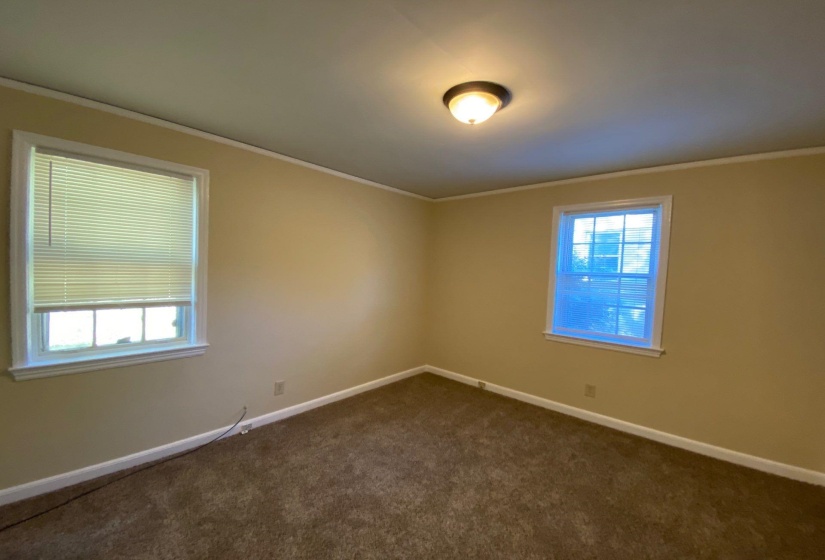 Spare room with dark carpet and ornamental molding
