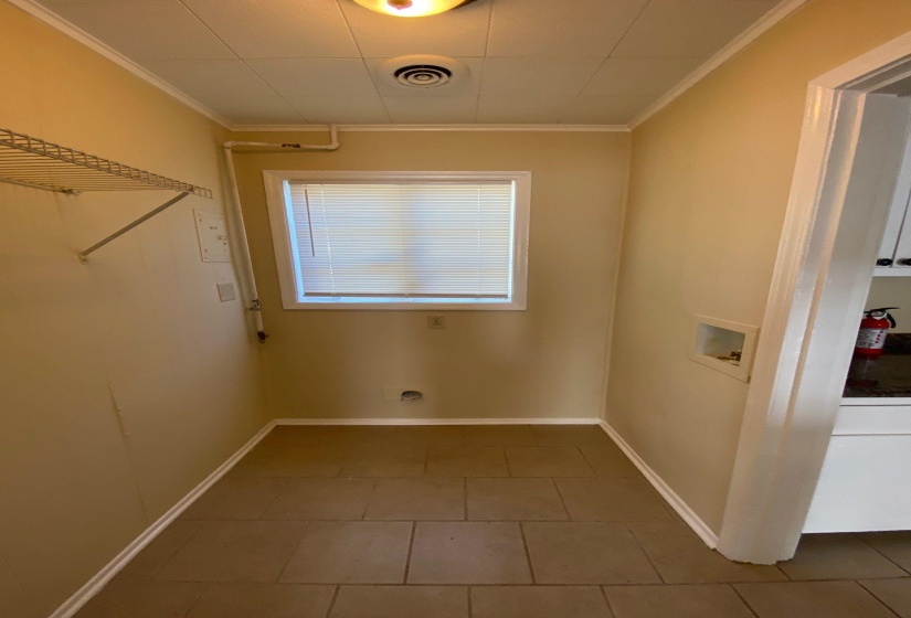 Laundry room with washer hookup, ornamental molding, and tile patterned flooring