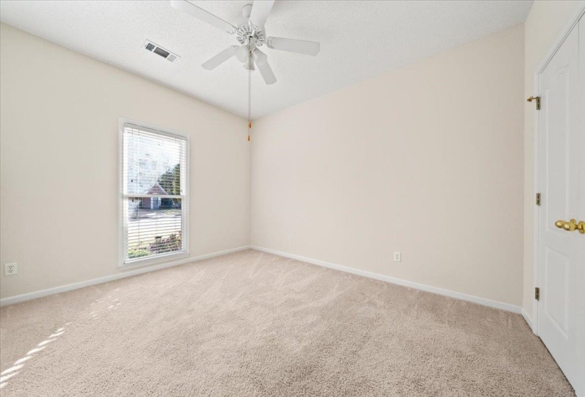 Empty room featuring light carpet, a textured ceiling, and ceiling fan