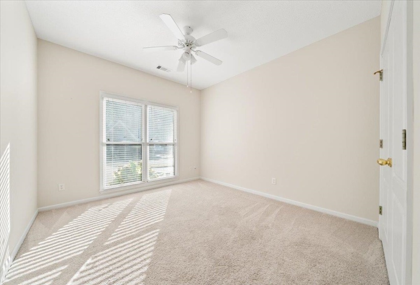 Spare room with light colored carpet and a ceiling fan