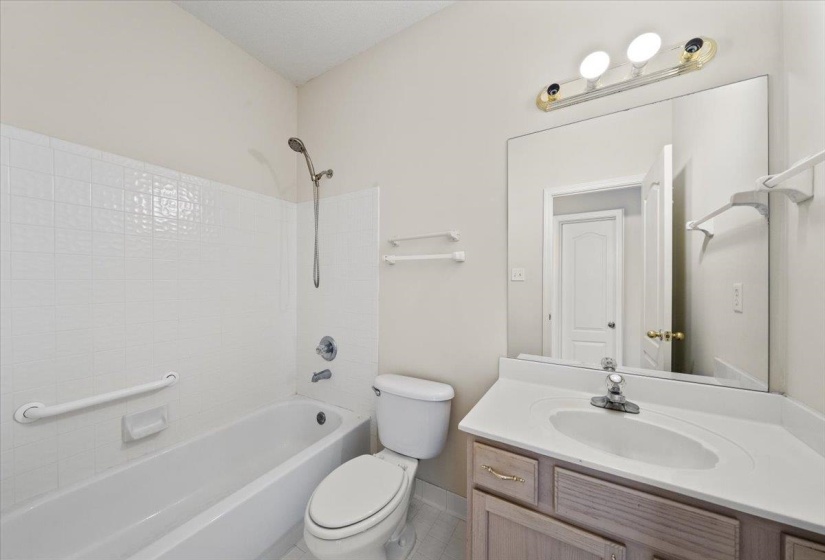 Bathroom featuring shower / bath combination, vanity, and light tile patterned floors