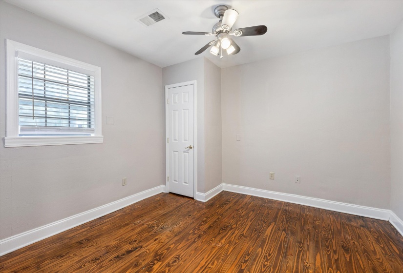 Unfurnished room featuring dark wood-style flooring and ceiling fan