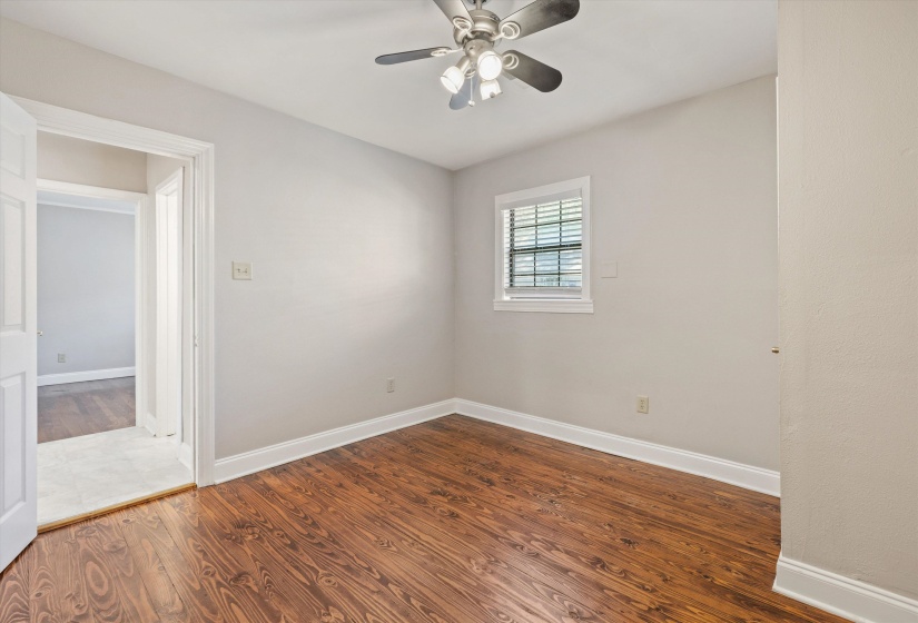 Spare room with dark wood-style flooring and ceiling fan