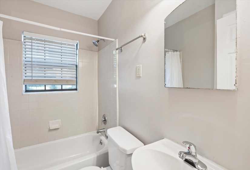 Full bath featuring toilet and shower / bath combo with shower curtain