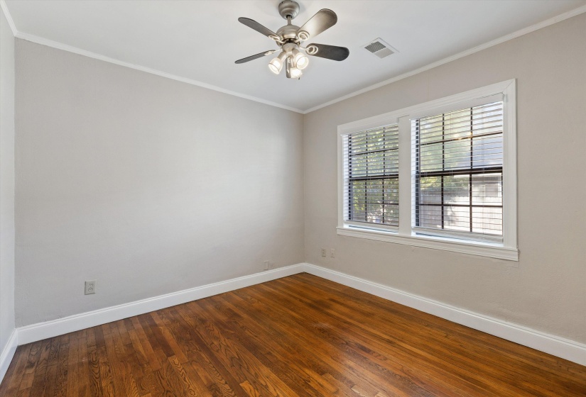Spare room with ornamental molding, dark wood-style floors, and ceiling fan
