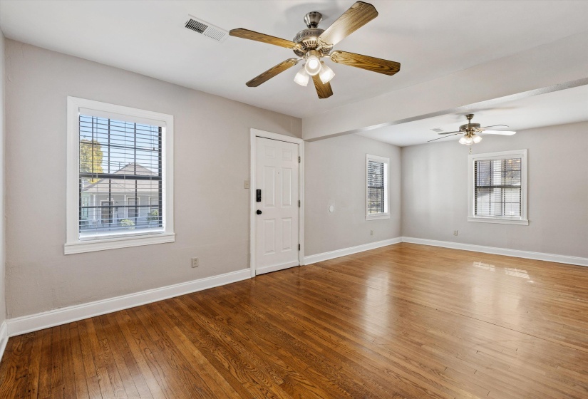 Spare room featuring healthy amount of natural light, hardwood / wood-style flooring, and a ceiling fan
