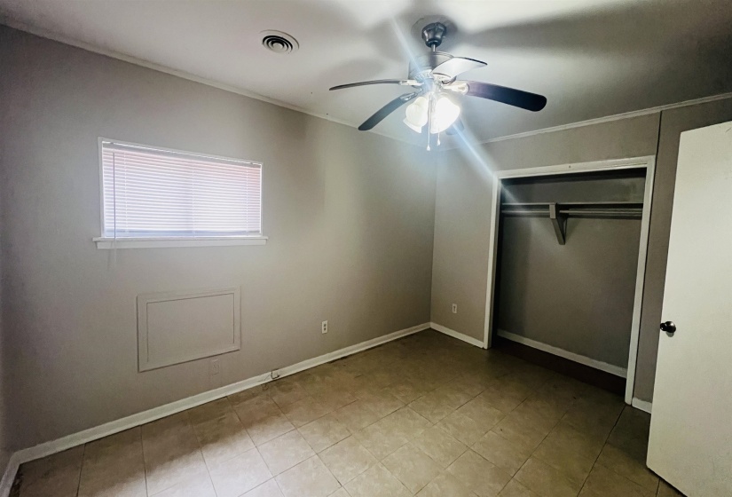 Unfurnished bedroom with a closet, ceiling fan, and crown molding