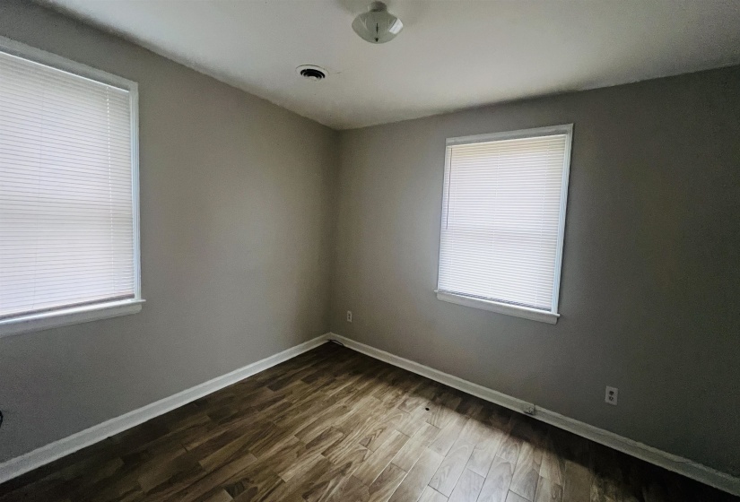 Spare room with baseboards and dark wood-style floors