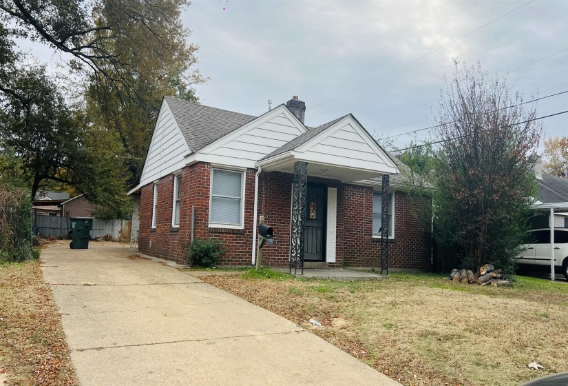 Bungalow with brick siding, a front lawn, a chimney, concrete driveway, and a shingled roof