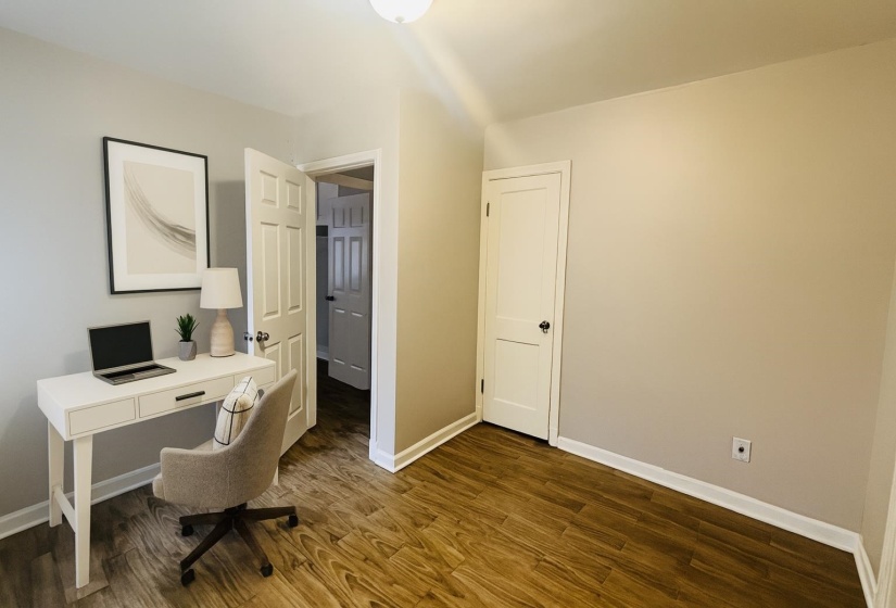 Office area with baseboards and dark wood-style flooring