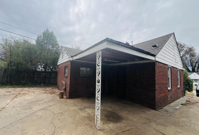 View of home's exterior featuring an attached carport, brick siding, a patio, and concrete driveway