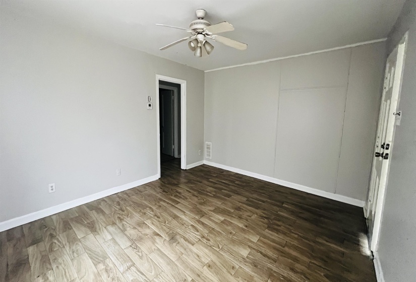 Unfurnished room with dark wood-style floors and ceiling fan