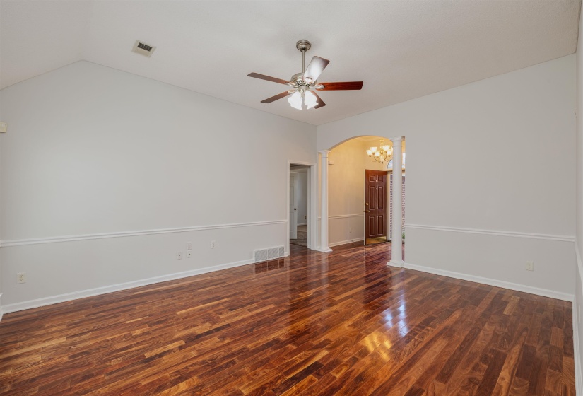Family room with dark wood finished floors, arched walkways, and ceiling fan