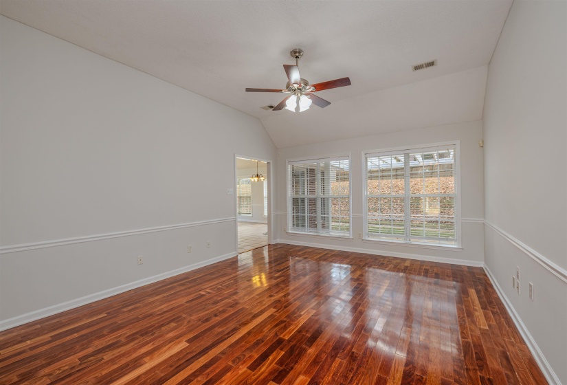 Family Room w chandelier, lofted ceiling, and ceiling fan