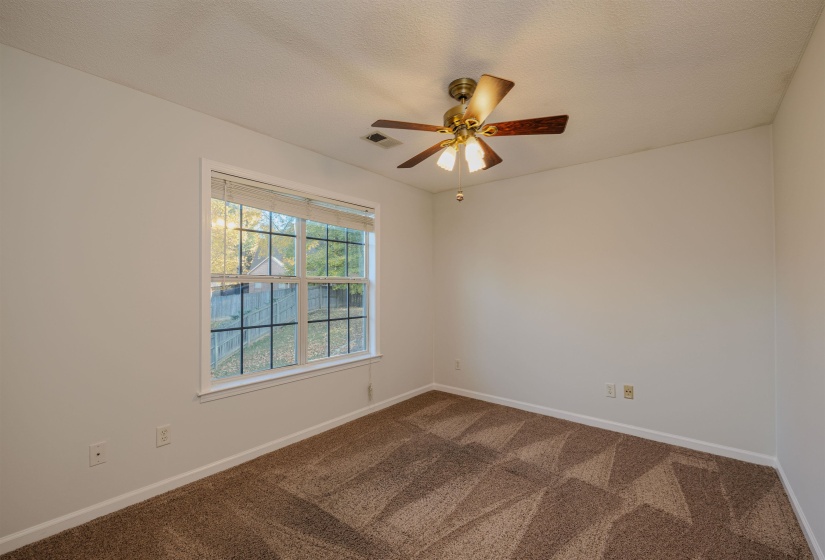 Bedroom featuring dark carpet, a textured ceiling, and a ceiling fan