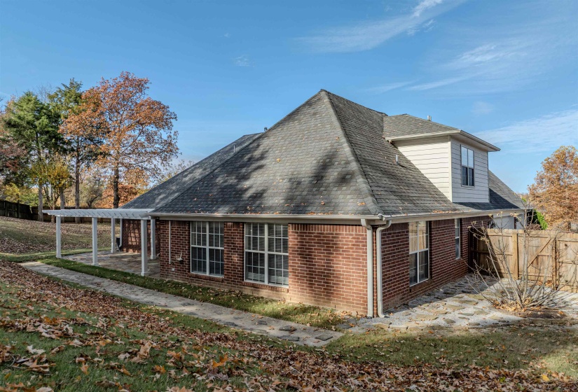 View of property exterior featuring brick siding and roof with shingles