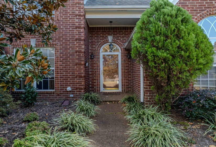 View of exterior entry featuring brick siding and roof with shingles