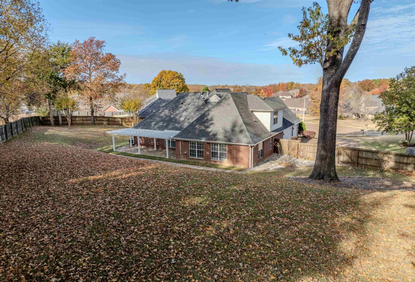View of property exterior featuring a fenced backyard, brick siding, a shingled roof, and a patio area