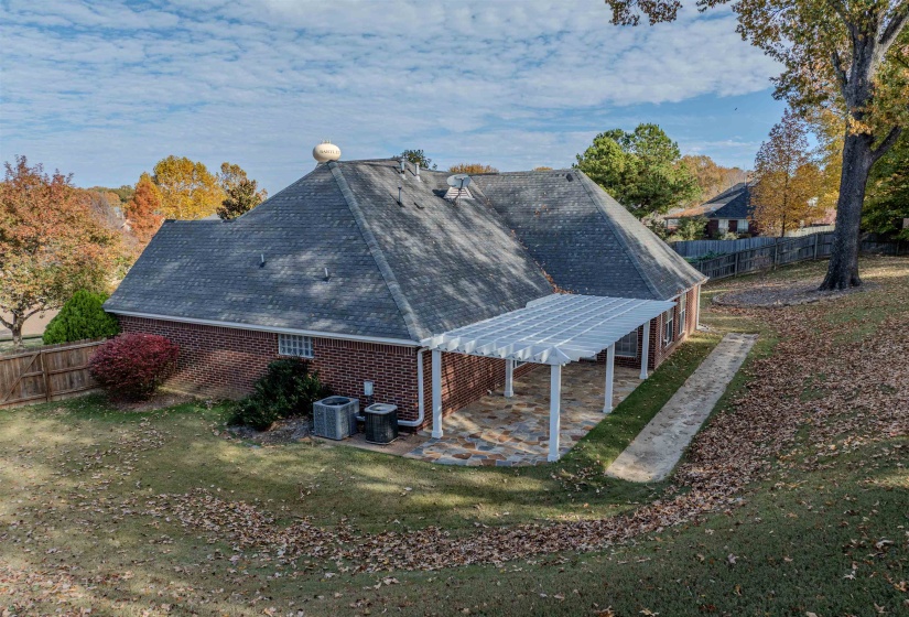 View of side of home with a fenced backyard, a patio, and a shingled roof