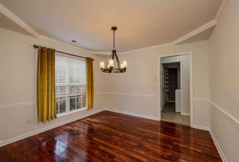 Dining room with a chandelier, ornamental molding, and dark wood-style flooring