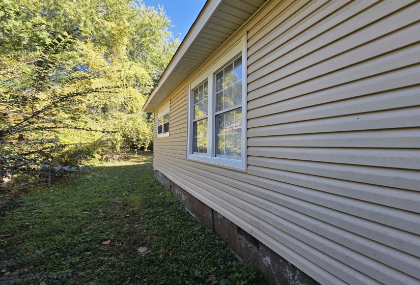 View of side of home with a lawn
