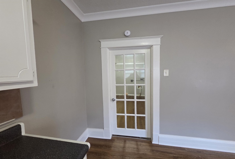 Doorway to outside with wood finished floors and ornamental molding