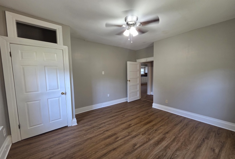 Unfurnished bedroom featuring dark wood-style floors and a ceiling fan